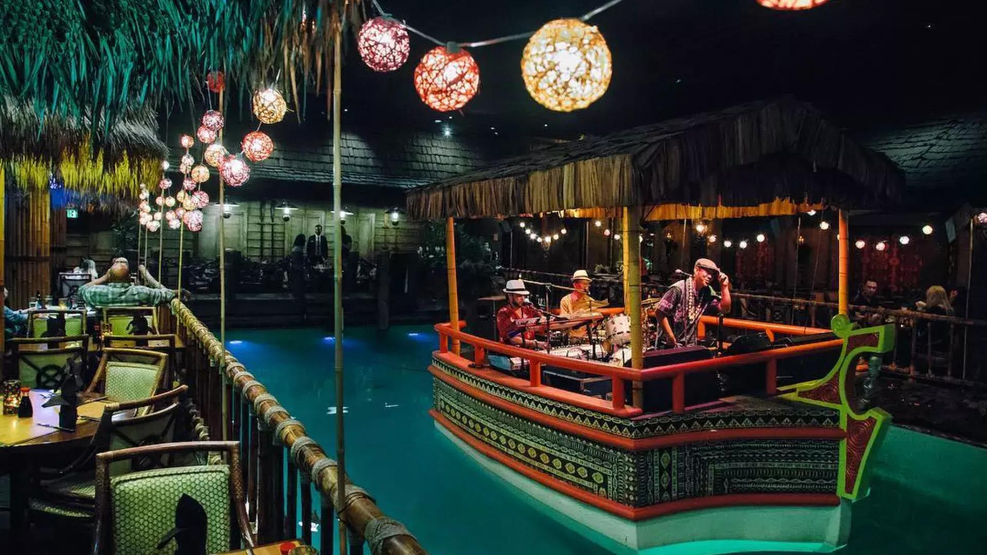 乐队在贝博体彩app费尔蒙酒店举世闻名的汤加房间的泻湖里演奏.