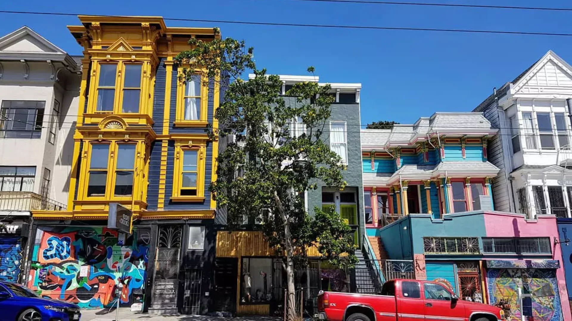 View of colorful buildings on Haight Street with cars parked along the street. San Francisco, California.