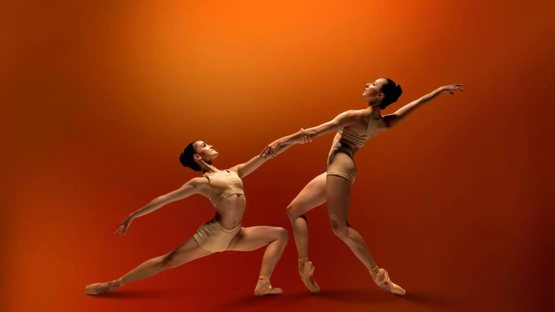 SF ballet dancers holding hands on a red background 