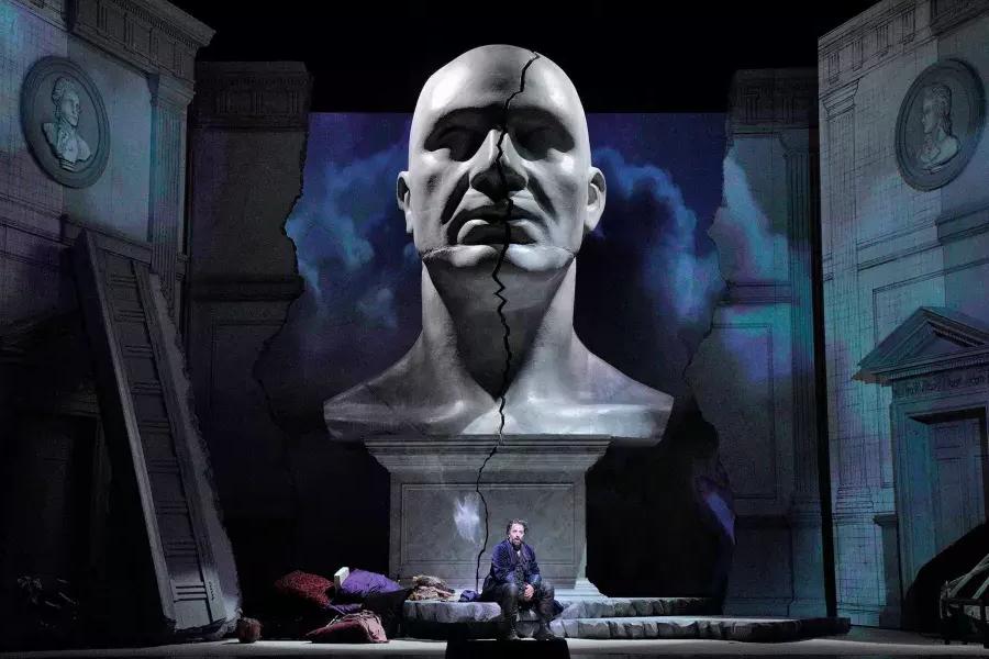 Un busto gigante de un hombre se cierne sobre dos actores en el escenario de una producción de Don Giovanni en San Francisco.