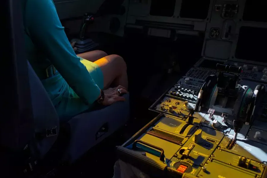 Hands near controls in the cockpit.