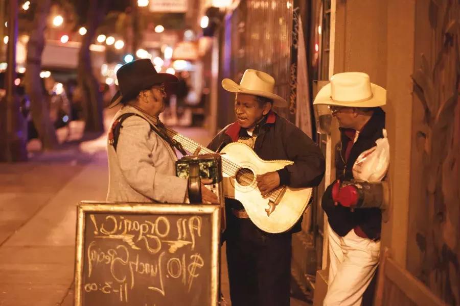 Three Mexican musicians perform on a street in the Mission District of San Francisco.