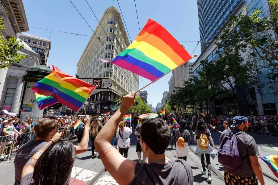 La gente que camina en el desfile del Orgullo de San Francisco ondea banderas del arco iris.