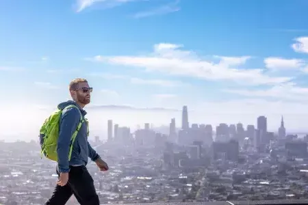 A visitor hikes to the top of Twin Peaks with his backpack.