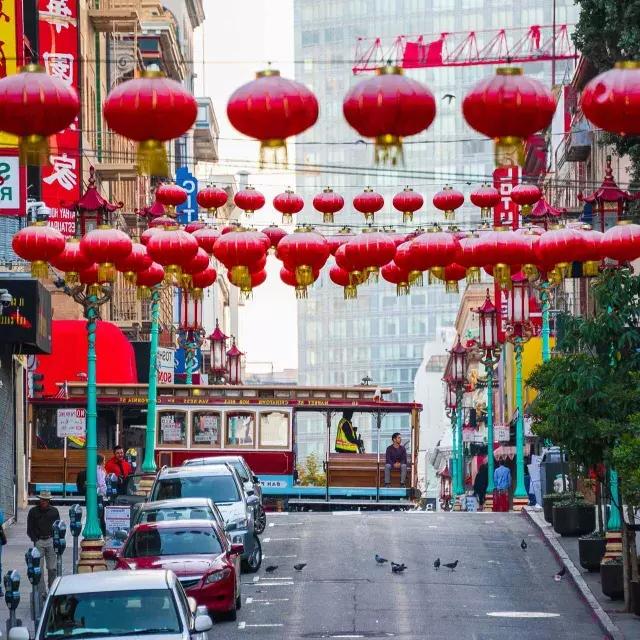 贝博体彩app唐人街连绵起伏的街道上悬挂着红色的灯笼，一辆有轨电车正在驶过。.